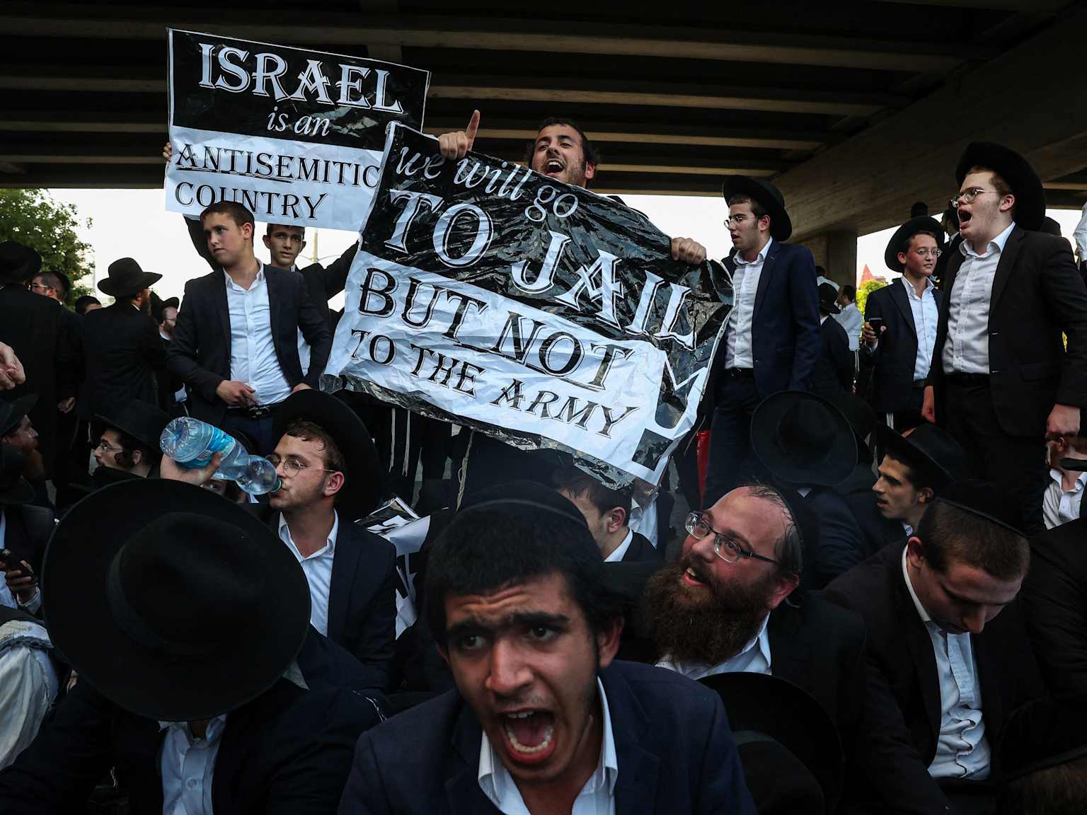 Manifestants ultra-orthodoxes brandissant des pancartes contre l'incorporation à l'armée israélienne
