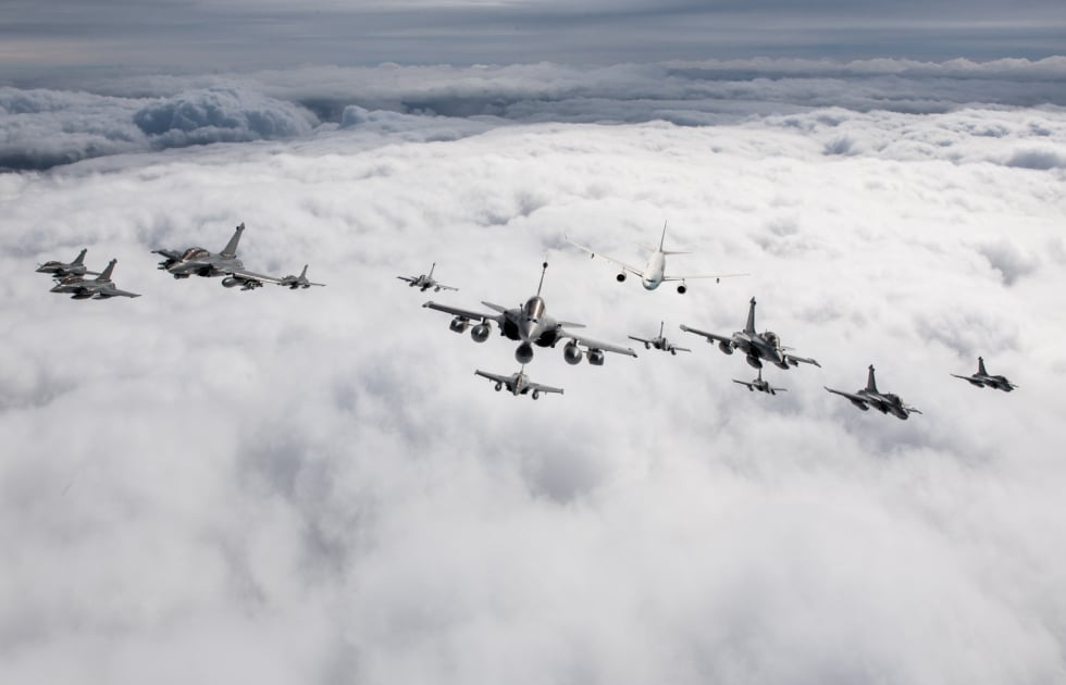 Raid of the French Strategic Air Forces: formation of Rafale fighters and an MRTT tanker in flight above the clouds